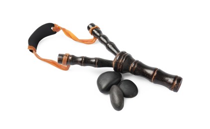 Photo of Black wooden slingshot with stones on white background