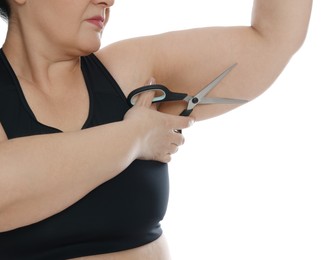 Photo of Obese woman with scissors on white background, closeup. Weight loss surgery