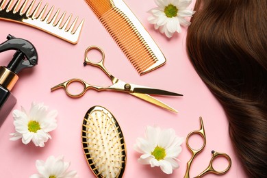 Photo of Flat lay composition with different hairdresser tools and flowers on pink background