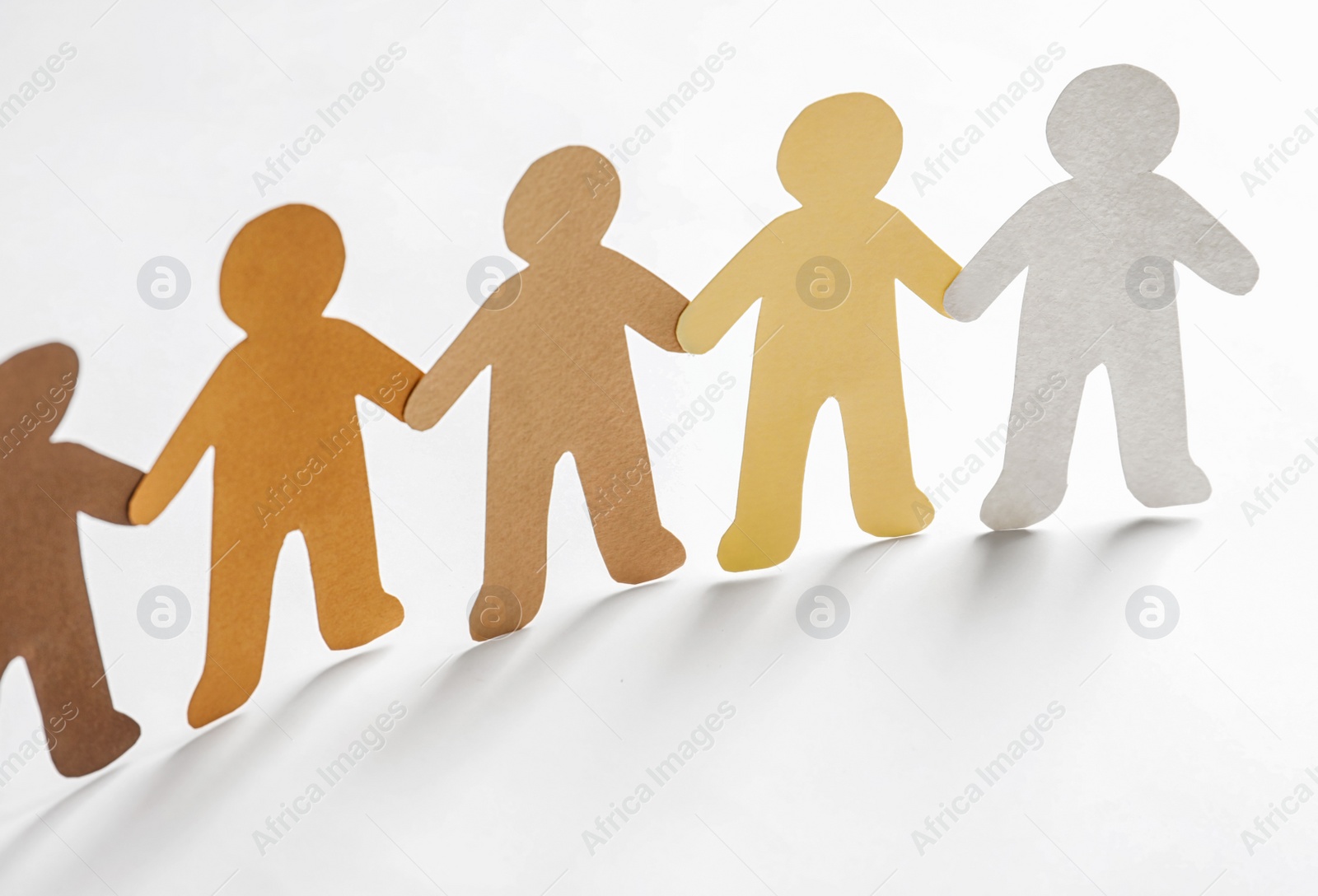 Photo of Paper people holding hands on light background. Unity concept