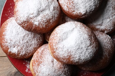 Delicious sweet buns with powdered sugar on plate, top view