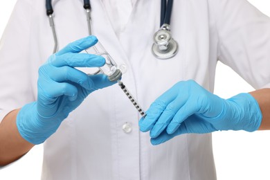 Photo of Doctor filling syringe with medication from glass vial on white background, closeup