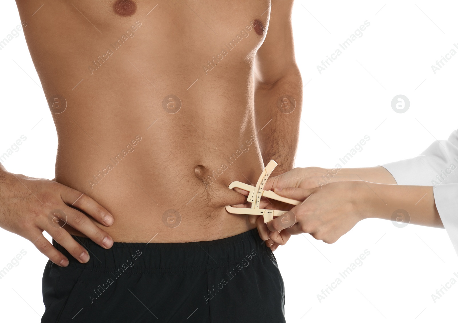 Photo of Nutritionist measuring man's body fat layer with caliper on white background, closeup