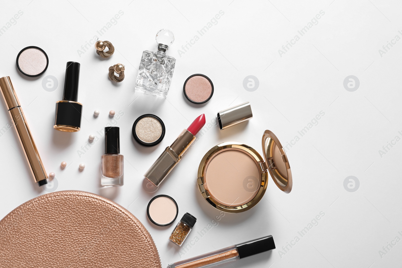Photo of Cosmetic bag and different luxury makeup products on white background, top view