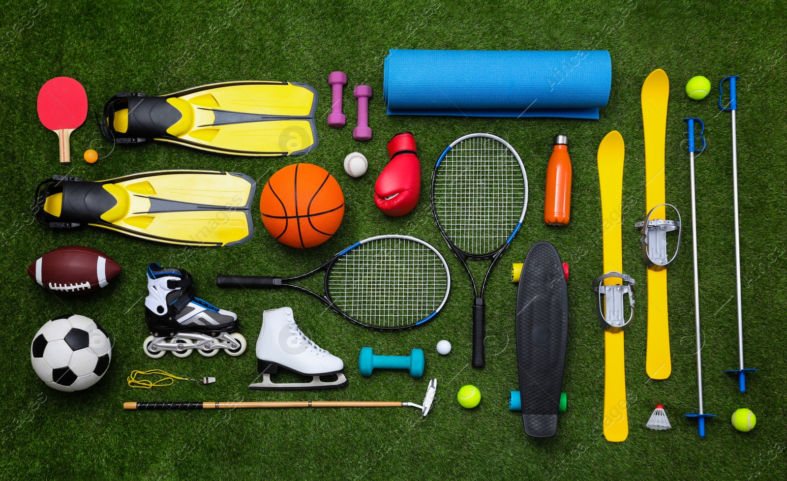 Photo of Different sport equipment on green grass, flat lay