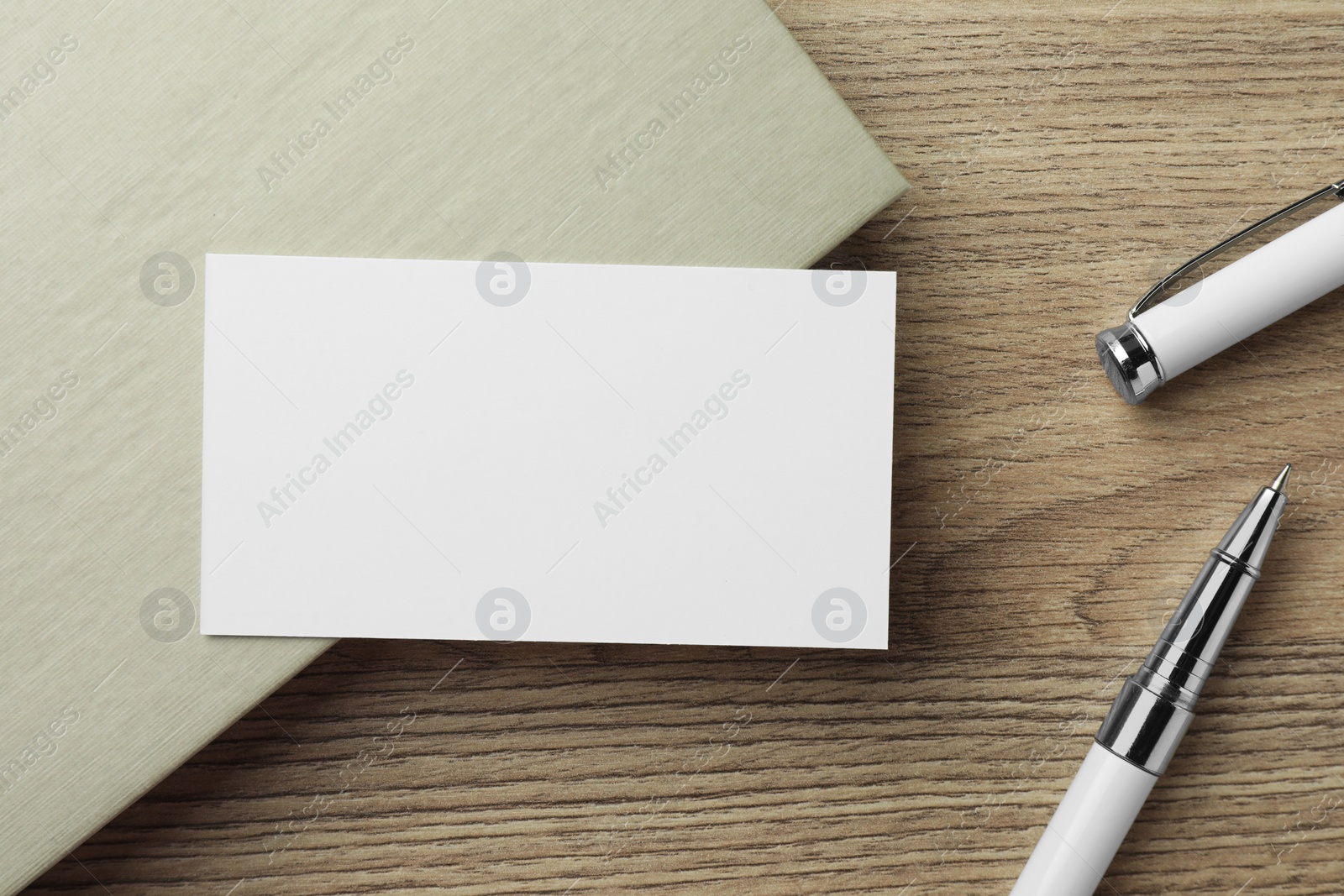 Photo of Blank business card, notebook and pen on wooden table, flat lay. Mockup for design
