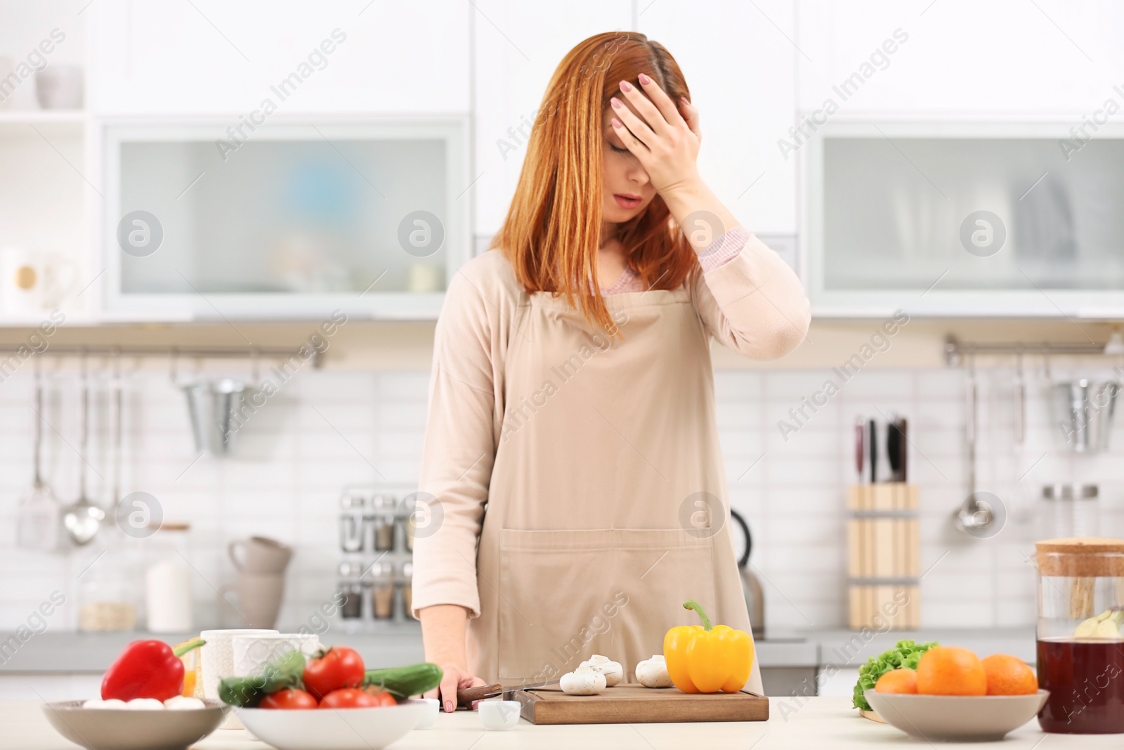 Photo of Tired housewife cooking in kitchen