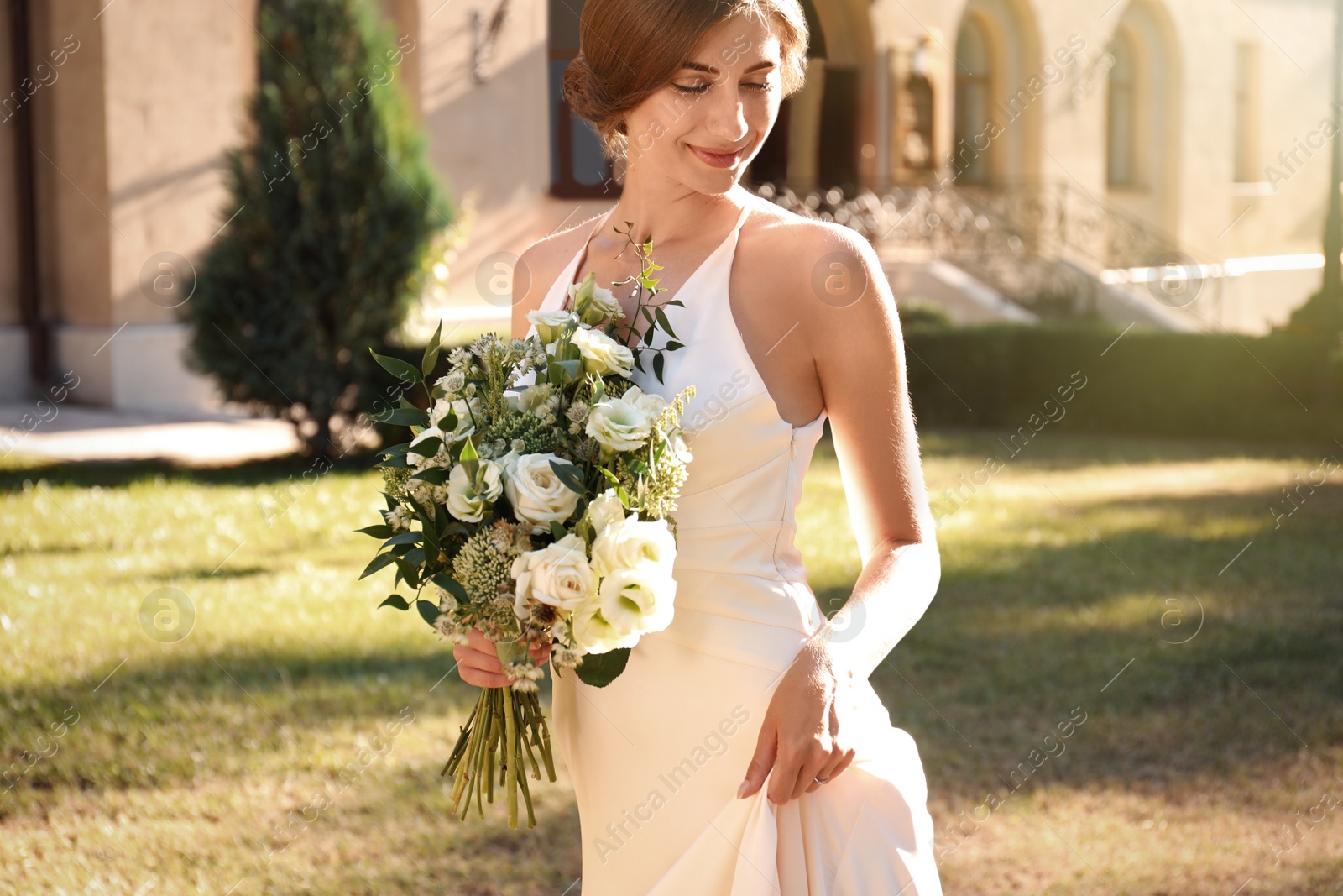 Photo of Gorgeous bride in beautiful wedding dress with bouquet outdoors