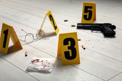 Evidences and crime scene marker on white wooden table