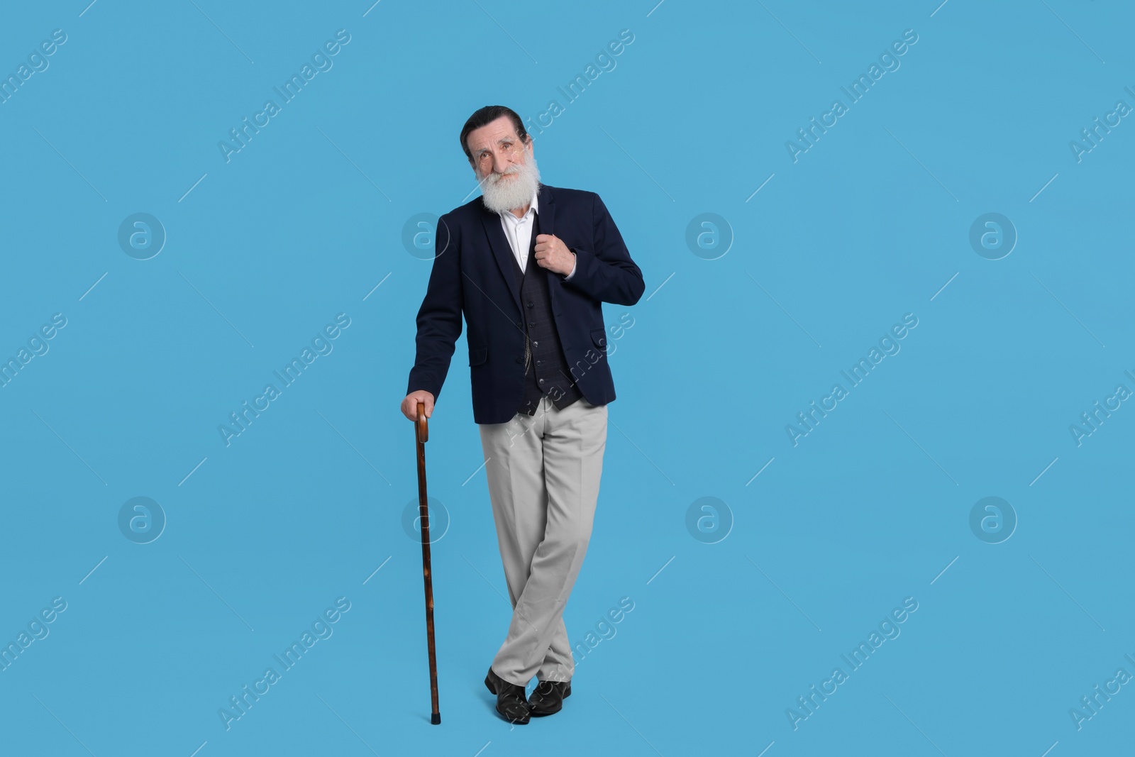 Photo of Senior man with walking cane on light blue background