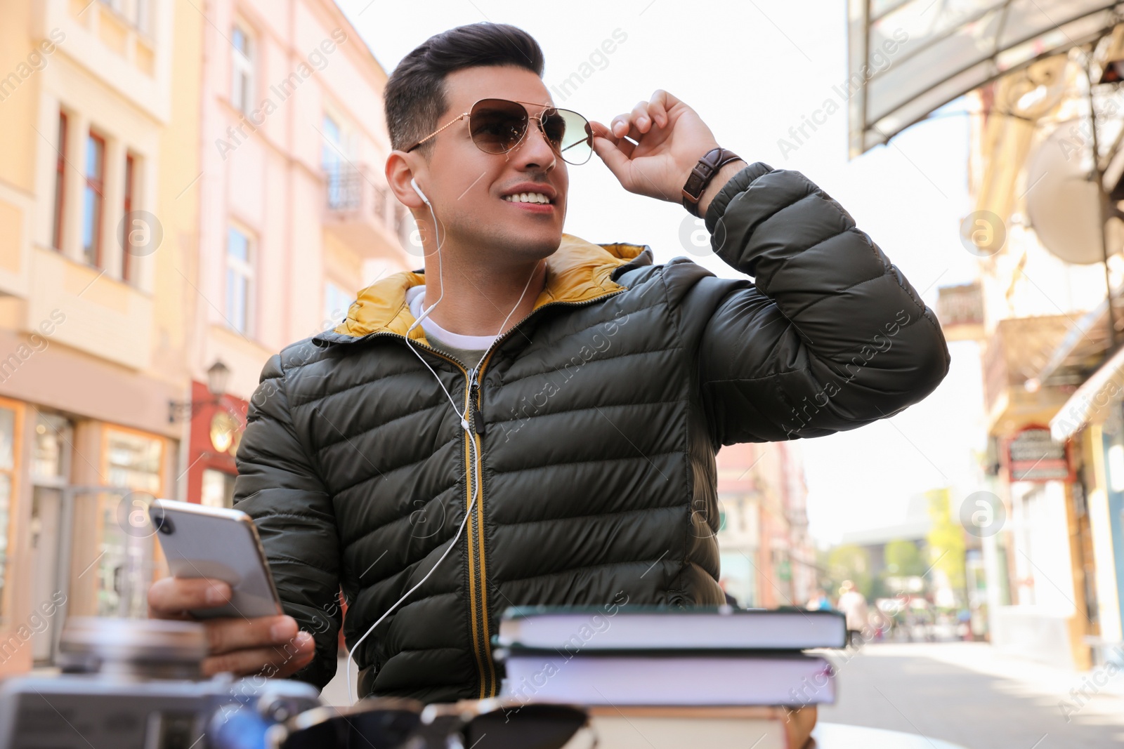 Photo of Man listening to audiobook in outdoor cafe