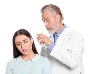 Photo of Doctor spraying medication into woman's ear on white background