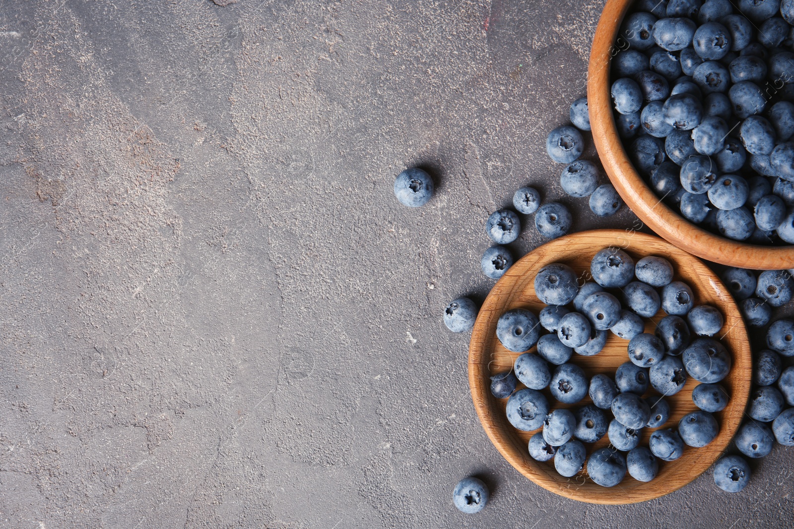 Photo of Flat lay composition with juicy blueberries and space for text on color table