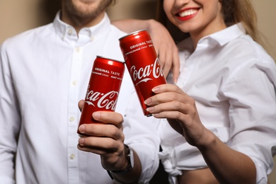 MYKOLAIV, UKRAINE - NOVEMBER 28, 2018: Young couple with Coca-Cola cans on color background, closeup