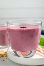 Glass of blackberry smoothie on white table, closeup