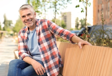 Handsome mature man on bench in park