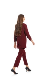 Photo of Young woman in burgundy suit walking on white background