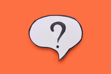 Photo of Paper speech bubble with question mark on orange background, top view