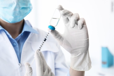 Female doctor with vial and syringe in hospital. Vaccination day