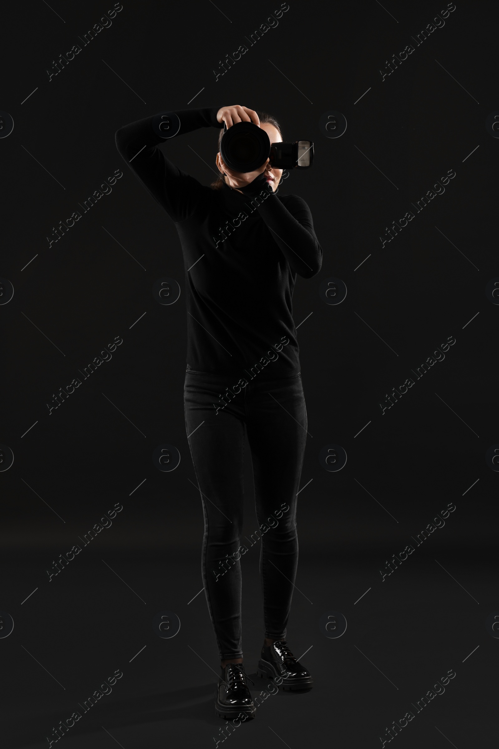 Photo of Professional photographer taking picture on black background