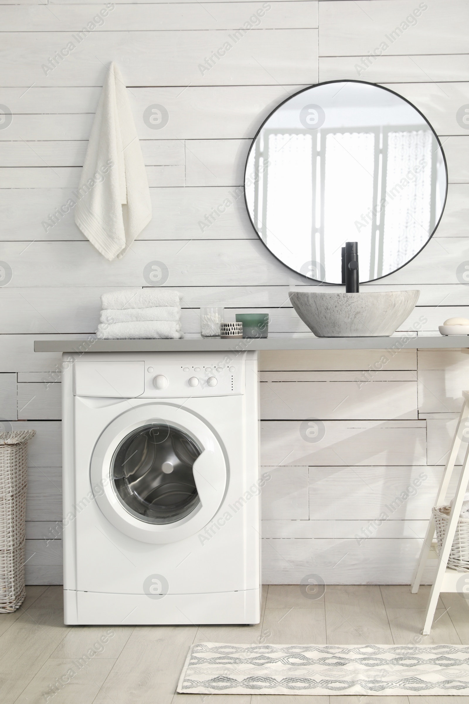 Photo of Stylish bathroom interior with modern washing machine