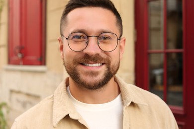 Photo of Portrait of handsome bearded man in glasses outdoors