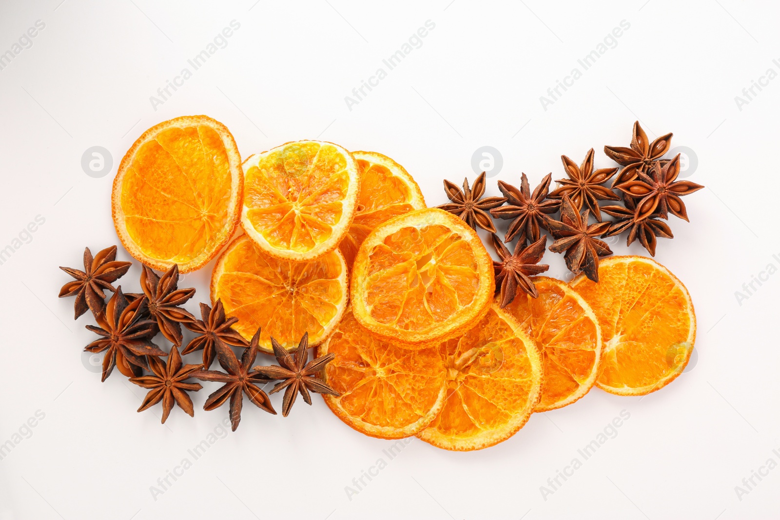 Photo of Dry orange slices and anise stars on white background, flat lay