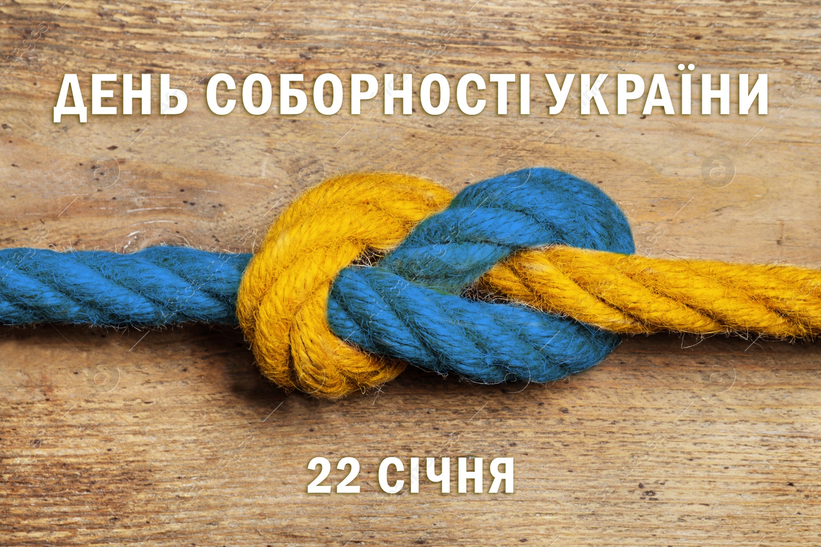 Image of Unity Day of Ukraine poster design. Color ropes tied together, map and text written in Ukrainian on wooden background