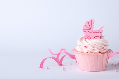 Photo of Beautifully decorated baby shower cupcake with pink cream and girl topper on light background. Space for text