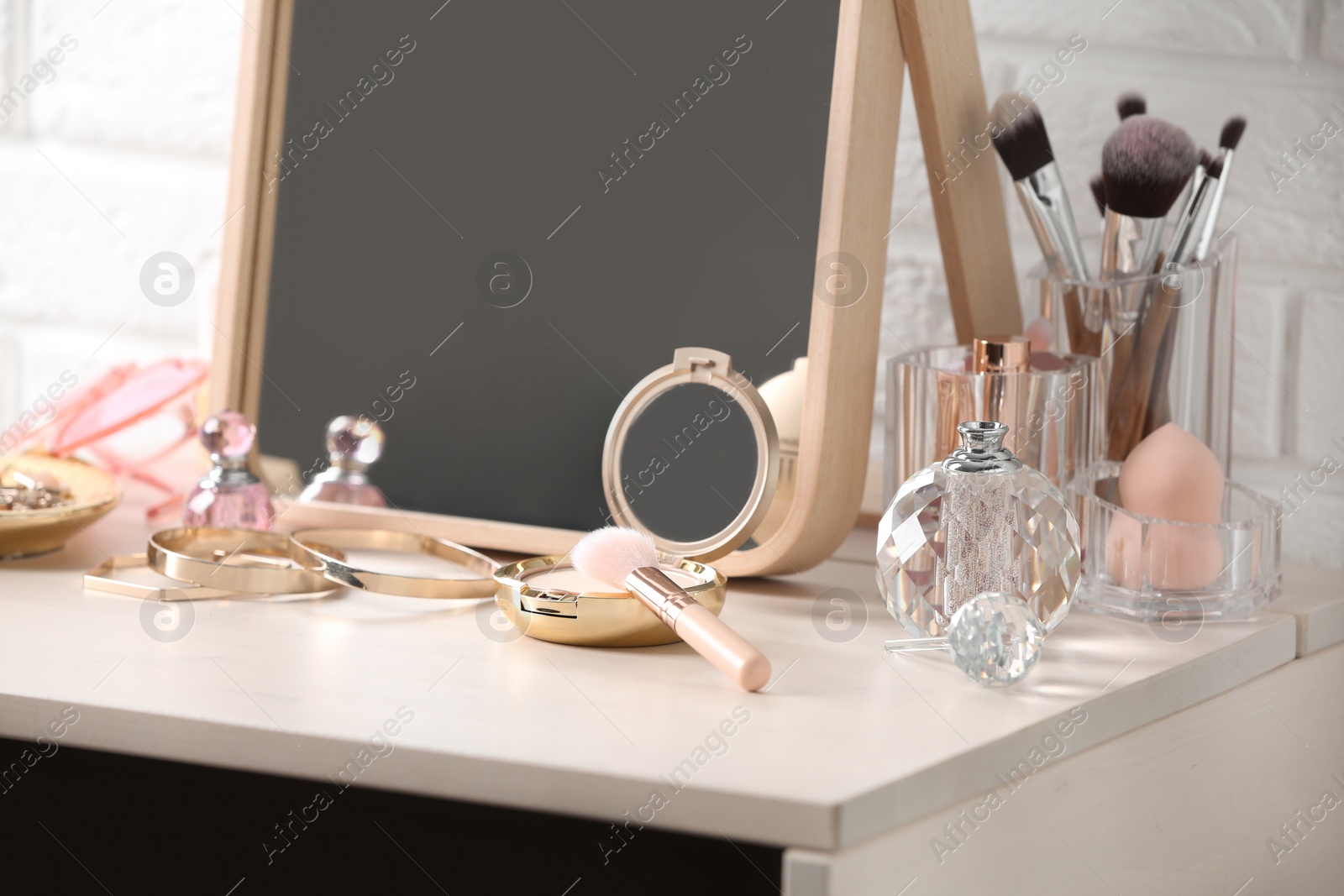 Photo of Different makeup products and accessories on dressing table