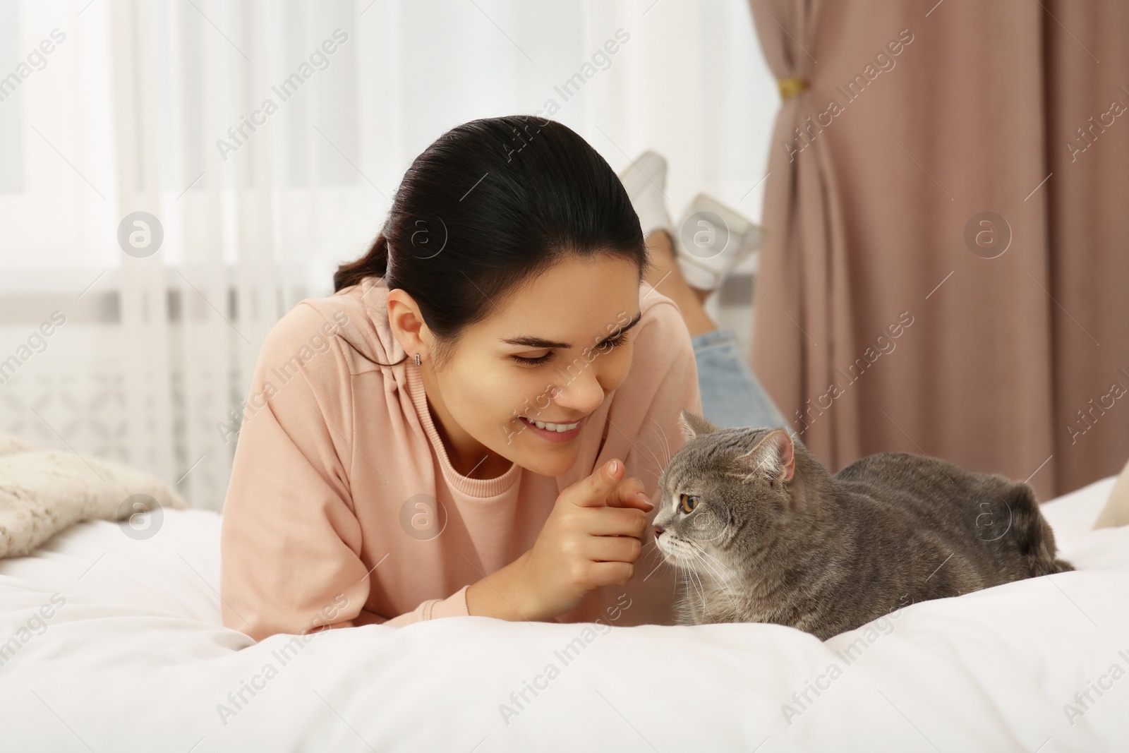 Photo of Young woman with adorable cat at home