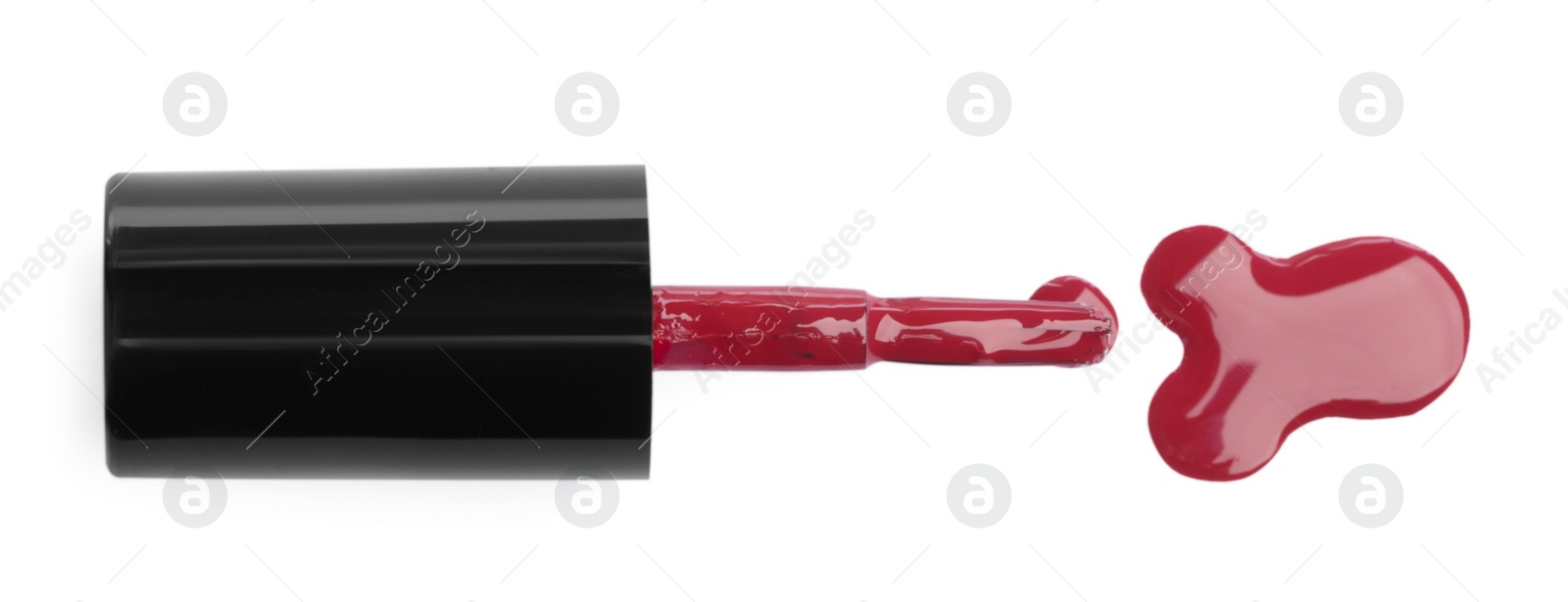 Photo of Brush and spilled red nail polish isolated on white, top view