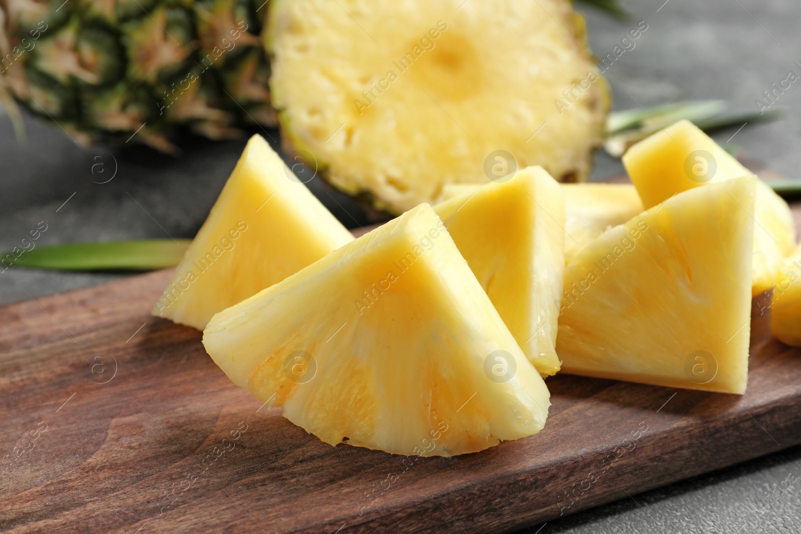 Photo of Wooden board with fresh sliced pineapple, closeup