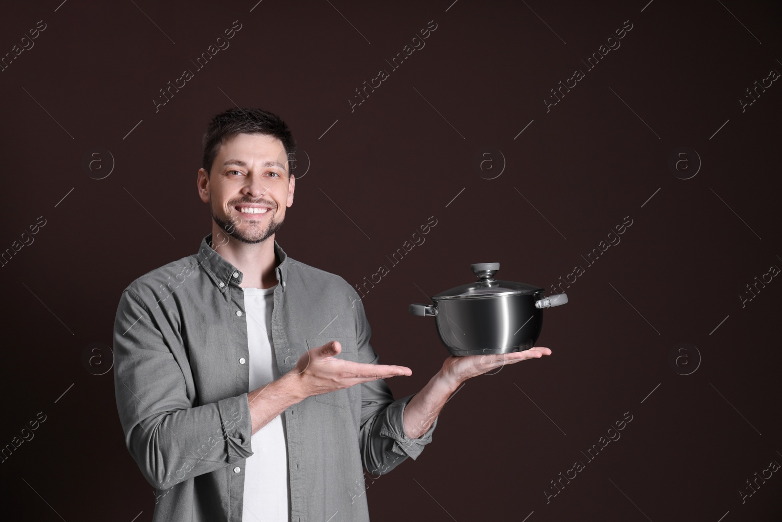 Photo of Happy man with pot on dark background