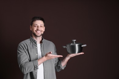 Happy man with pot on dark background