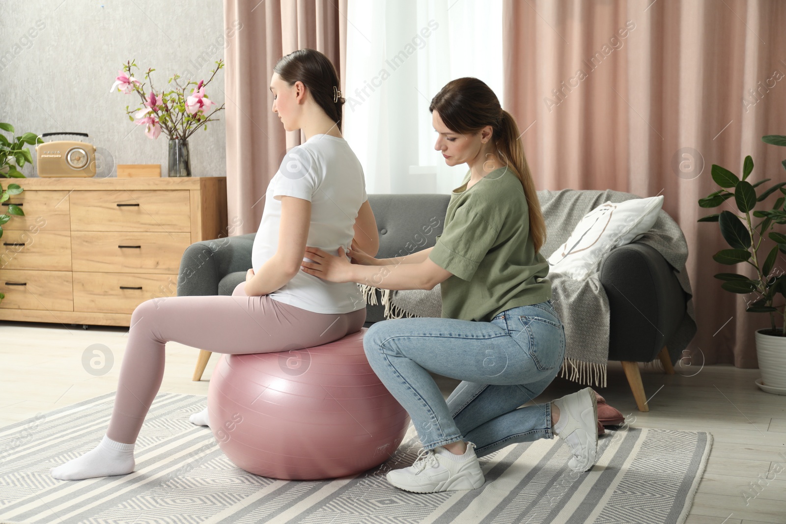 Photo of Doula massaging pregnant woman at home. Preparation for child birth