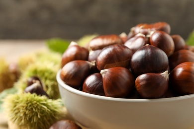 Photo of Fresh sweet edible chestnuts in bowl, closeup