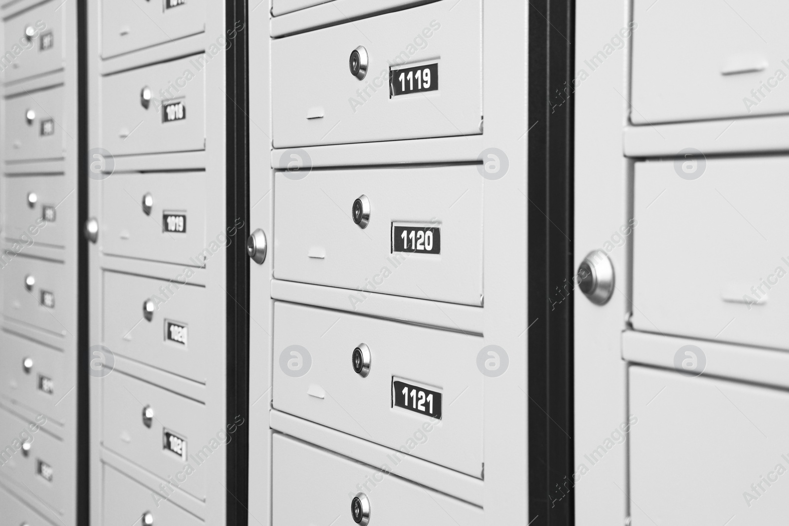 Photo of Closed metal mailboxes with keyholes and sequence numbers indoors