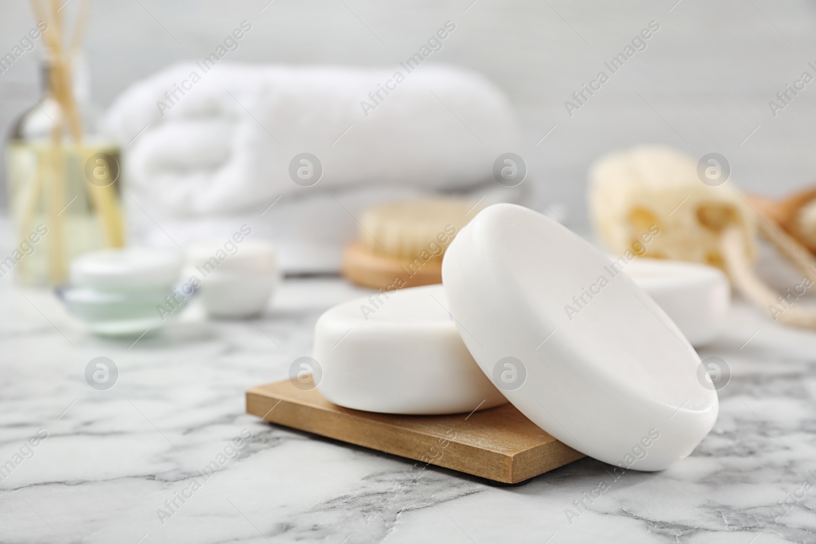 Photo of White soap bars on wooden deck in bathroom, closeup