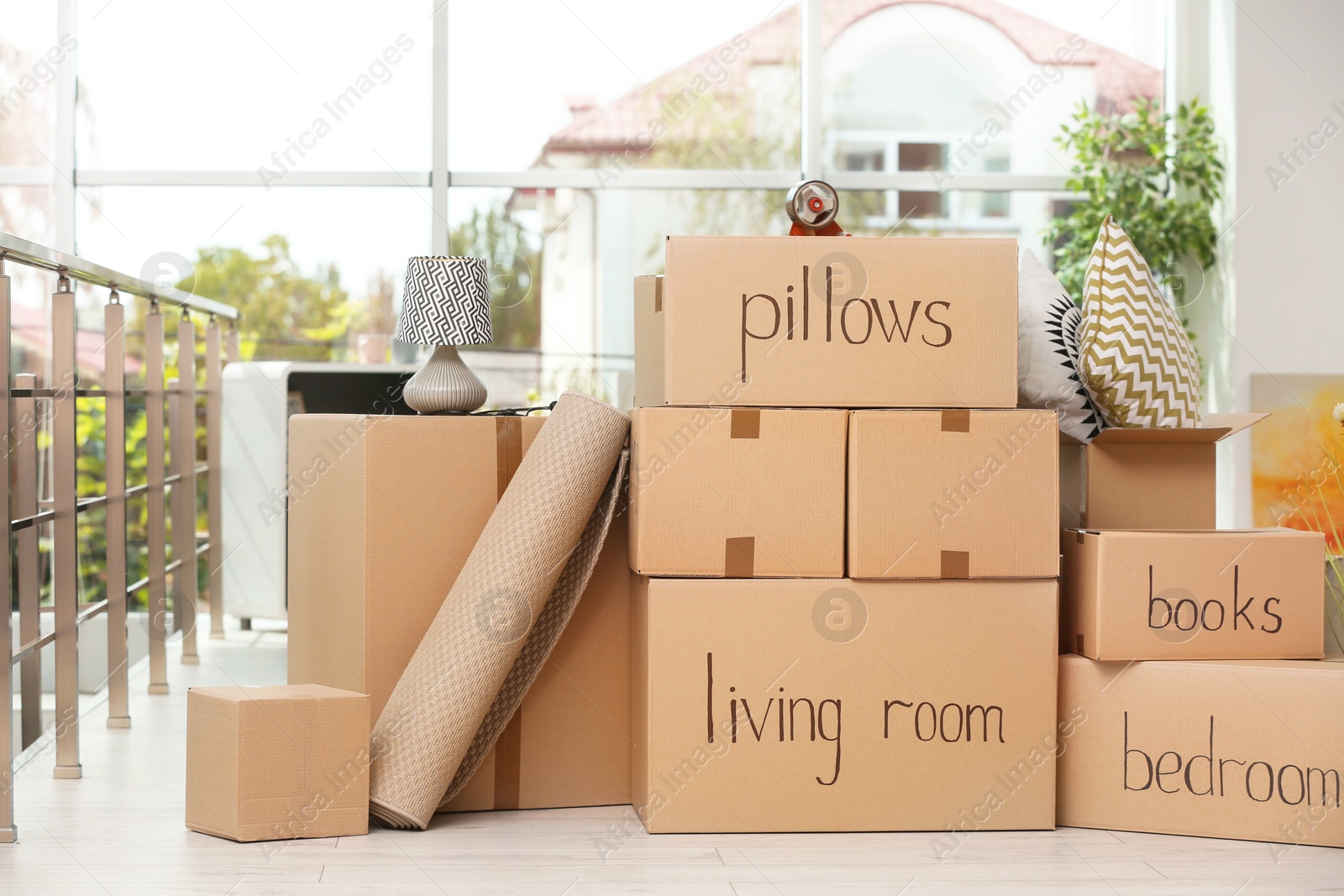 Photo of Cardboard boxes and household stuff indoors. Moving day