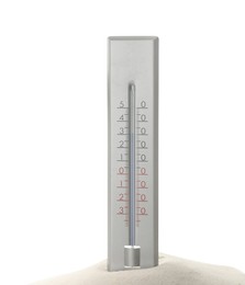 Weather thermometer in sand against white background