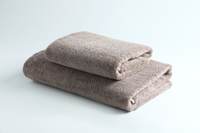 Photo of Stack of fresh fluffy towels on grey background