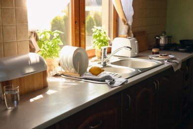 Photo of Stylish kitchen interior with sink and toaster near window