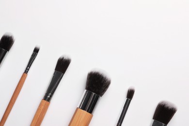 Set of makeup brushes on white background, flat lay. Space for text