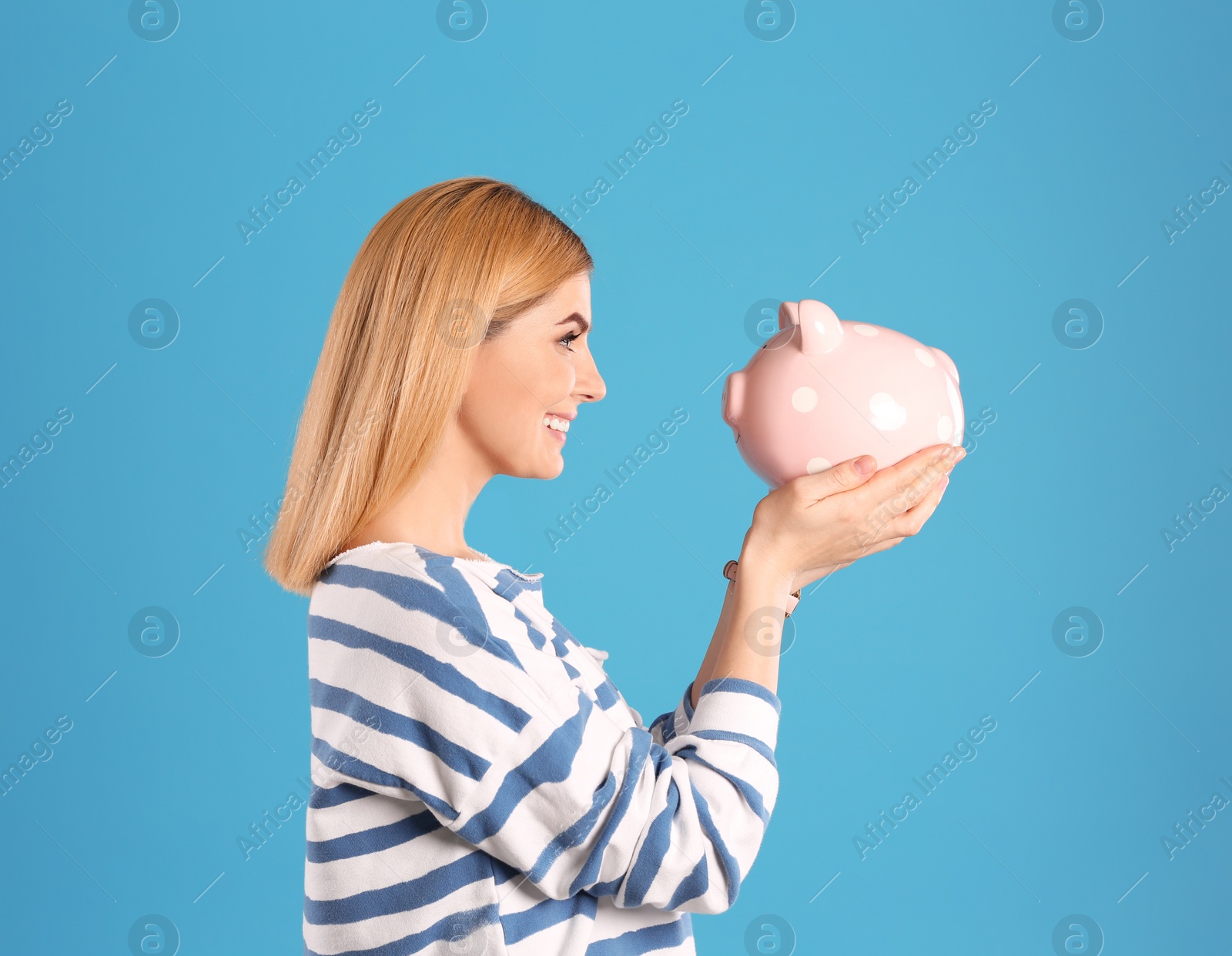 Photo of Woman with piggy bank on color background