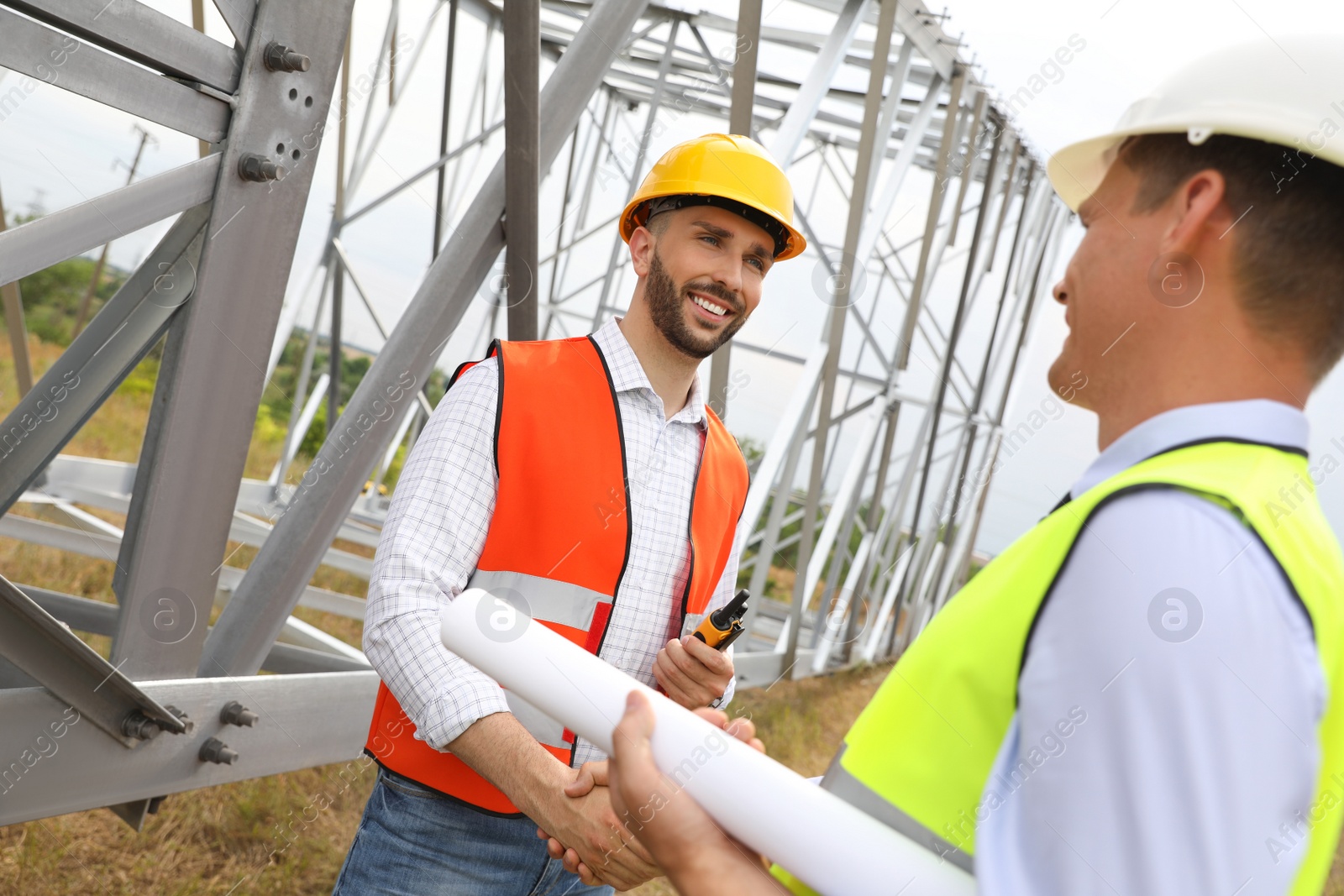 Photo of Professional engineers working on installation of electrical substation outdoors