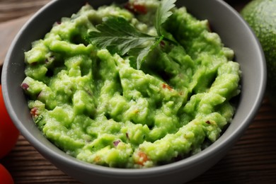 Photo of Delicious guacamole with parsley on table, closeup
