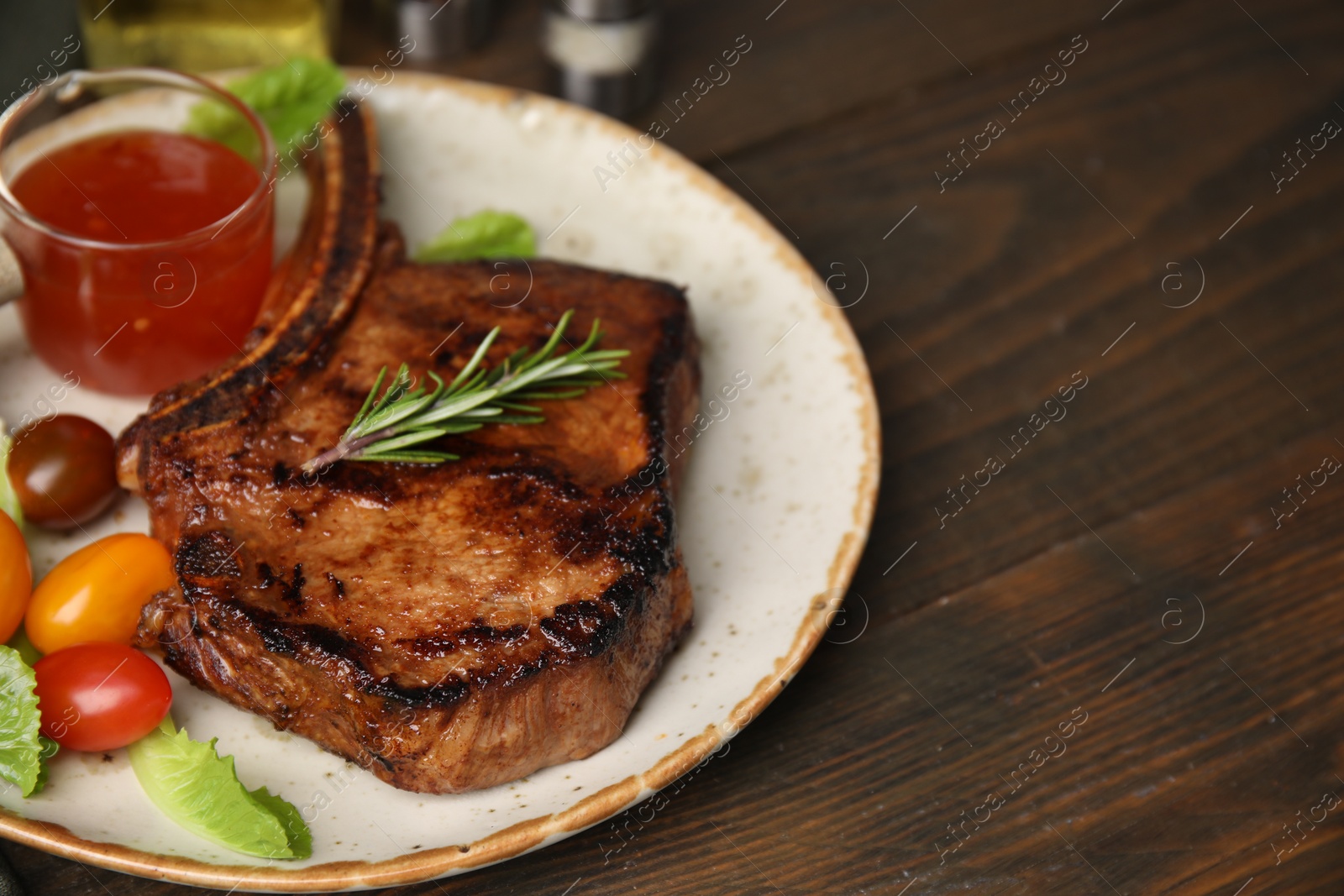 Photo of Tasty meat, rosemary, tomatoes and marinade on wooden table, closeup. Space for text