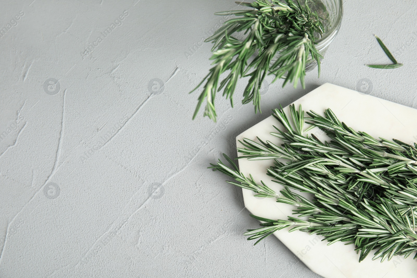 Photo of Flat lay composition with fresh rosemary twigs on grey table. Space for text