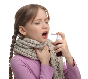 Photo of Little girl with scarf using throat spray on white background